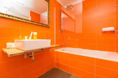 an orange bathroom with a sink and a bath tub at Violeta Boutique in Barcelona
