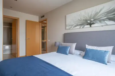 a bedroom with a large bed with blue and white pillows at Rent Top Apartments Forum in Sant Adria de Besos
