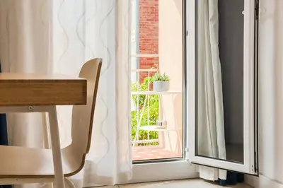 a room with a window with a table and a chair at Novus Homes Barcelona Collblanc in Hospitalet de Llobregat