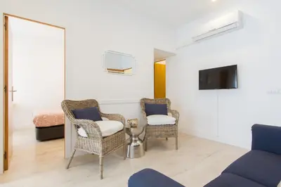 a living room with two chairs and a tv at Novus Homes Barcelona Collblanc in Hospitalet de Llobregat