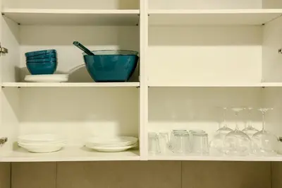 a cabinet filled with bowls and plates and glasses at Novus Homes Barcelona Collblanc in Hospitalet de Llobregat