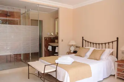 a bedroom with a bed and a chair and a window at Hotel restaurant Ceferino in Vilanova i la Geltrú