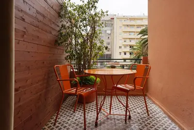 a table and chairs on a balcony with a window at Numa Barcelona Roca in Barcelona