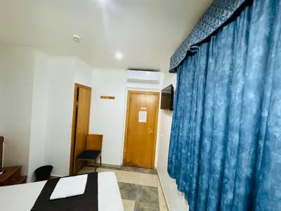 a room with a bed and a blue curtain at Hostal Mont Thabor in Barcelona