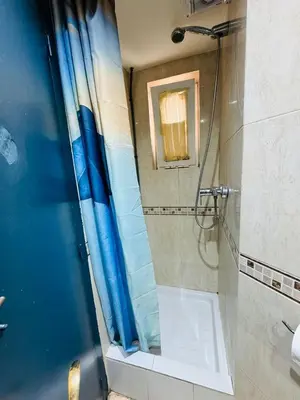 a shower with a blue shower curtain in a bathroom at Hostal Mont Thabor in Barcelona