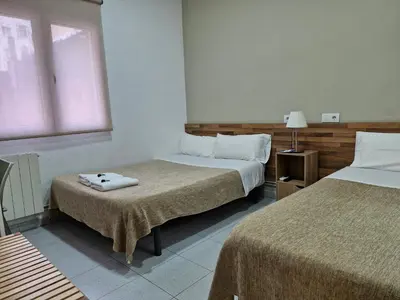 a hotel room with two beds and a window at Hostal Elkano in Barcelona