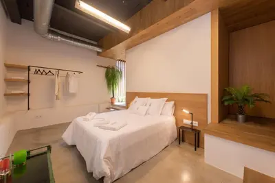 a bedroom with a large white bed in a room at Petit Luxe Loft in Terrassa