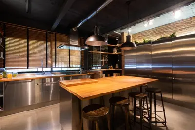 a kitchen with a wooden counter and bar stools at Petit Luxe Loft in Terrassa