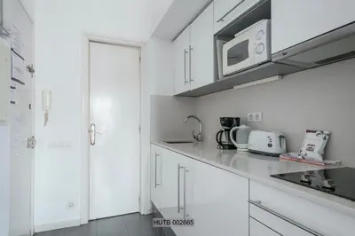 a kitchen with white cabinets and a microwave at Alcam Pau Claris in Barcelona