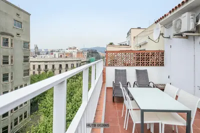 a balcony with a table and chairs on a building at Alcam Pau Claris in Barcelona