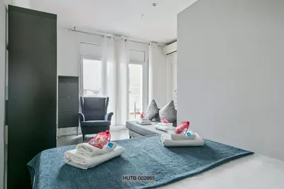 a room with two babies on a bed with a chair at Alcam Pau Claris in Barcelona