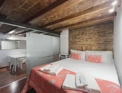 a bedroom with a bed and a brick wall at Stay U-nique Apartments Plaça Universitat in Barcelona