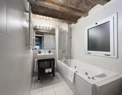 a bathroom with a tub and a sink and a tv at Stay U-nique Apartments Plaça Universitat in Barcelona
