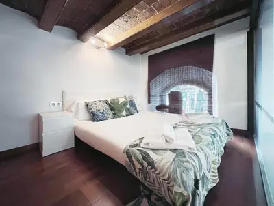 a bedroom with a bed and a brick wall at Stay U-nique Apartments Plaça Universitat in Barcelona