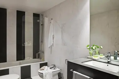 a bathroom with a sink and a toilet and a tub at AinB Sagrada Familia Apartments in Barcelona