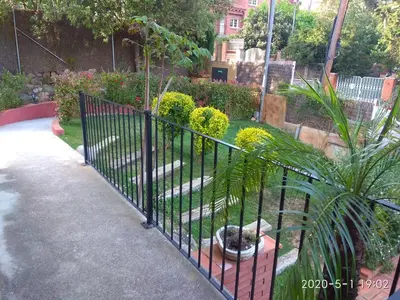 a black fence in a garden with plants at B&B Inés in Sant Cugat del Vallès