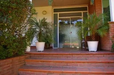 a front porch with potted plants on a house at B&B Inés in Sant Cugat del Vallès