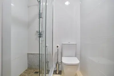 a bathroom with a toilet and a glass shower at Manresa Apartamentos Turísticos in Manresa