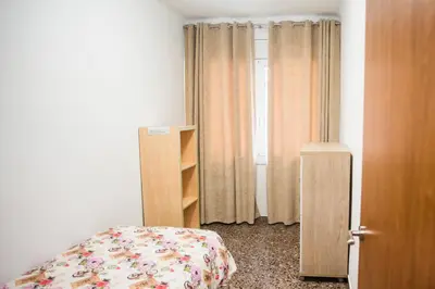 a bedroom with a bed next to a book shelf at Manresa Apartamentos Turísticos in Manresa