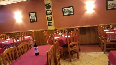 a restaurant with tables and chairs with a bottle of wine at Pensión Avenida in Vilafranca del Penedès