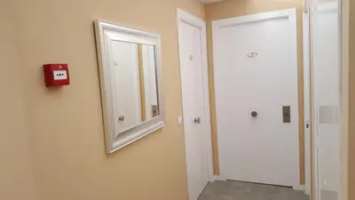a bathroom with a mirror on the wall and a door at Pensión Avenida in Vilafranca del Penedès