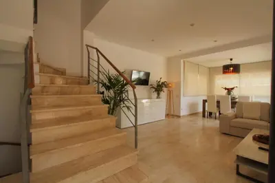 a living room with stairs and a dining room at Beach House Castelldefels in Castelldefels