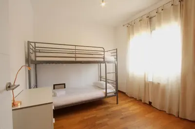 a bedroom with two bunk beds and a desk at Beach House Castelldefels in Castelldefels