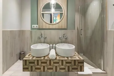 a bathroom with two sinks and a mirror at Habitat Apartments Alaia in Barcelona