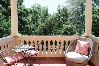 a porch with wicker chairs and a table on a balcony at Hotel Torre Barcelona in Sant Cugat del Vallès