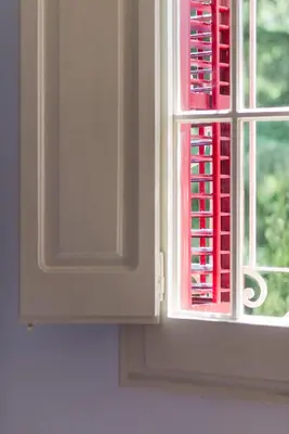a window with red shutters in a kitchen at Hotel Torre Barcelona in Sant Cugat del Vallès