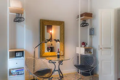 a room with a table and two chairs and a mirror at Habitació amb encant in Sitges