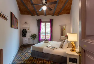 a bedroom with a large bed and a window at Primavera Hostel in Barcelona