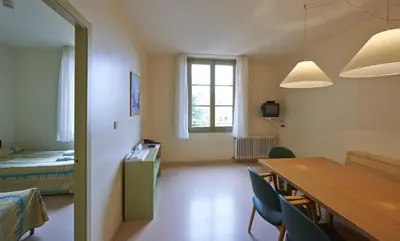 a room with a table and a bed and a table and chairs at Apartamentos Montserrat Abat Marcet in Montserrat