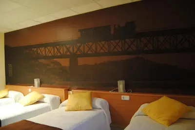 a room with three beds and a train painting on the wall at Guilleumes Montserrat in Monistrol