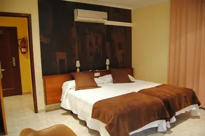 a bedroom with a large bed with a brown blanket at Guilleumes Montserrat in Monistrol