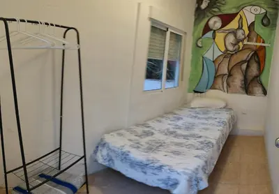 a room with a bed and a painting on the wall at Pintor Pahissa Rooms in Barcelona