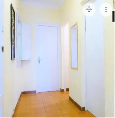 a hallway with a white door and a tile floor at Pintor Pahissa Rooms in Barcelona