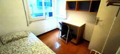 a room with a bed and a desk and a window at Pintor Pahissa Rooms in Barcelona