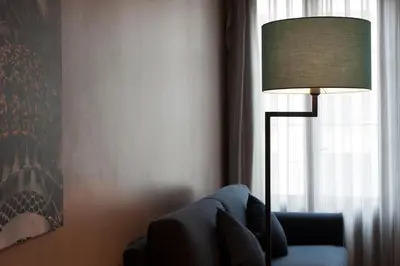 a living room with a blue couch and a lamp at MH Apartments Ramblas in Barcelona
