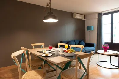 a dining room with a wooden table and chairs at MH Apartments Ramblas in Barcelona