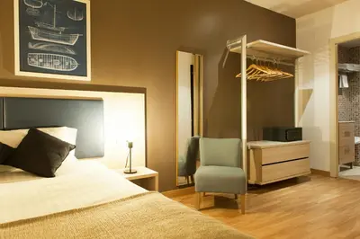 a bedroom with a bed and a chair and a desk at MH Apartments Ramblas in Barcelona