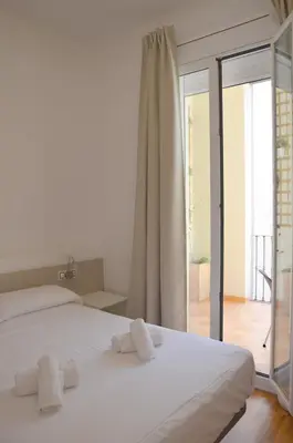 a bedroom with a white bed with towels on it at Claris Apartments in Barcelona