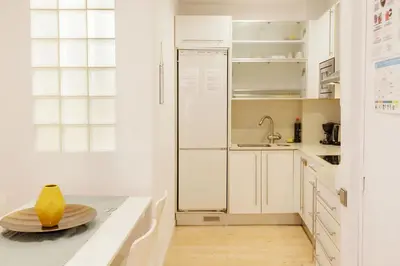 a kitchen with white cabinets and a refrigerator at Nice apartment in the middle of Born in Barcelona