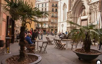a courtyard with tables and chairs and palm trees in a building at Nice apartment in the middle of Born in Barcelona