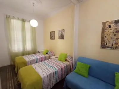 a room with two beds and a blue couch at Fira Plaza España Apartment 3ʳᵈ Floor Balcony in Barcelona
