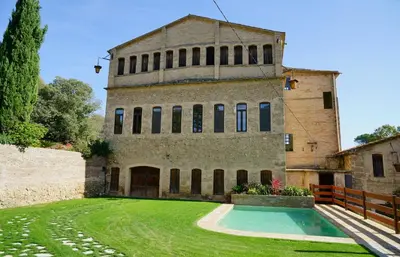 an old building with a swimming pool in the yard at El Molí Blanc in Lavid