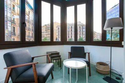 two chairs and a table in a room with windows at bp1- Piso para Grandes Grupos in Barcelona