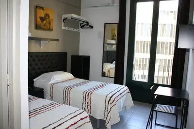 a hotel room with two beds and a mirror at Pensión Casa Blanca in Barcelona