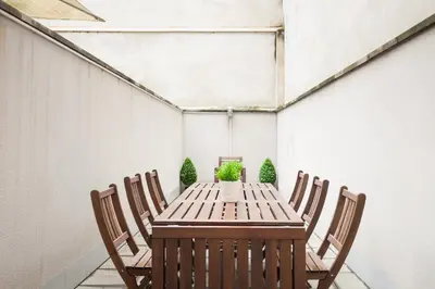 a dining room with a wooden table and chairs at ApartsNouBcn Fira Barcelona in Hospitalet de Llobregat