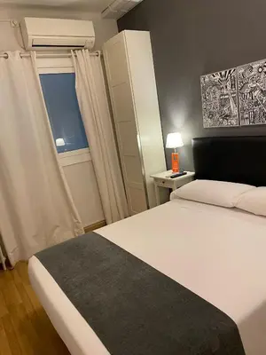 a bedroom with a white bed and a window at Hostal El Ninot in Barcelona